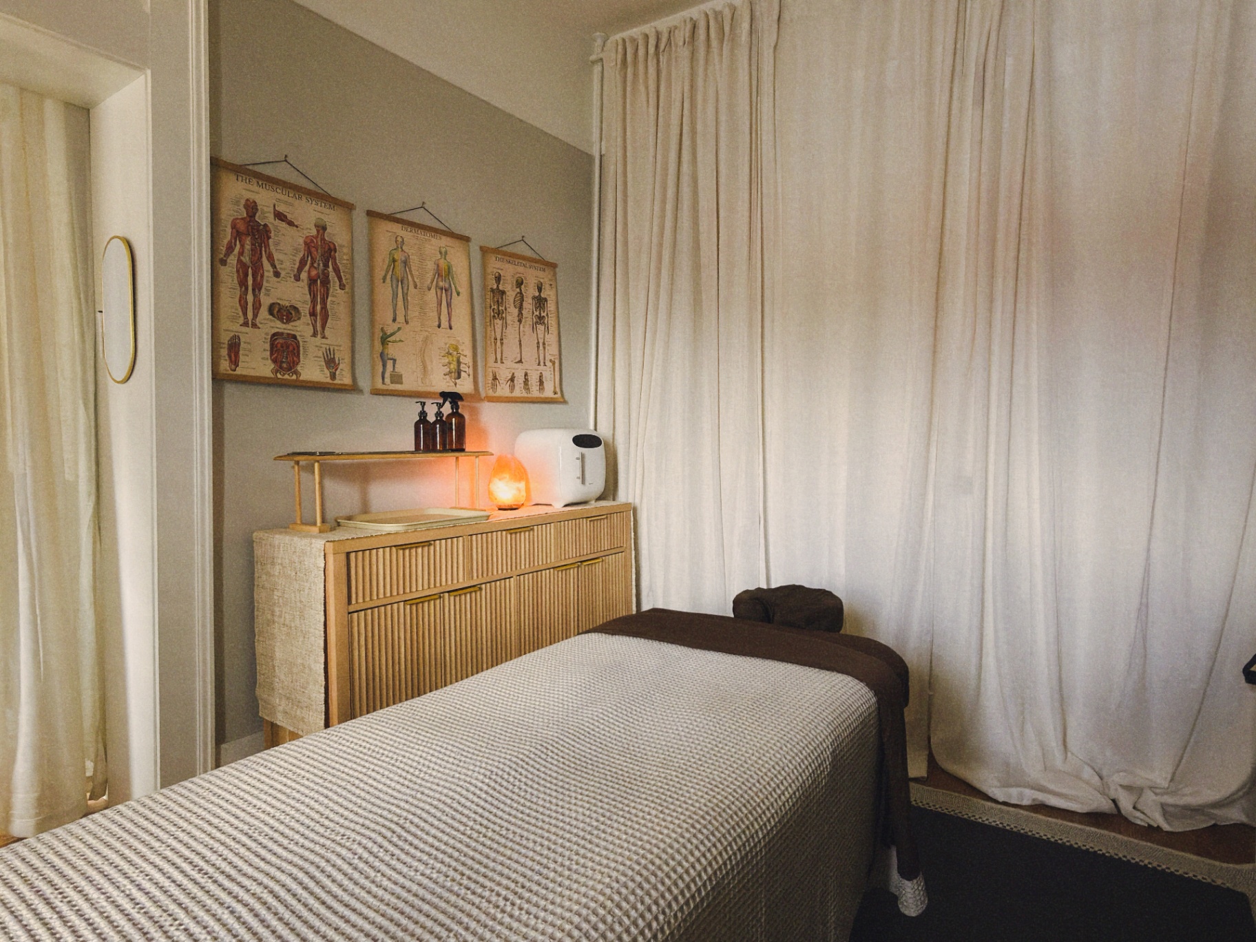 Studio Senti treatment room with anatomy charts and massage table